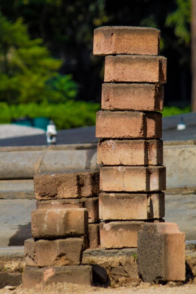 A stack of weathered bricks outdoors, perfect for construction and urban themes.